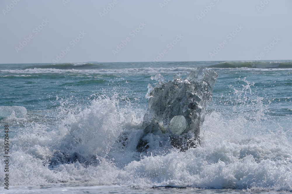 Naklejka premium Ice Floes and chunks wash up on pristine black sand beaches on the southern Iceland Coast from melting and calved glaciers