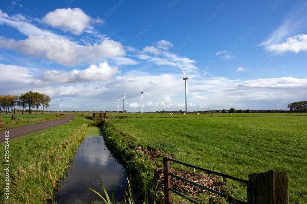 Eco power in nature landscape, Dutch landscape with windmills and cows grazing