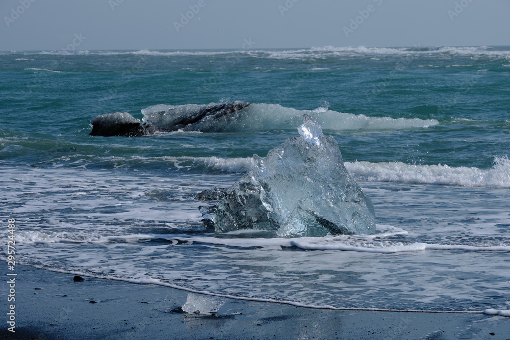 Obraz premium Ice Floes and chunks wash up on pristine black sand beaches on the southern Iceland Coast from melting and calved glaciers