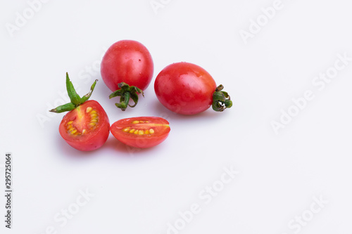 Grape or cherry tomato branch. Pile of red grape tomatoes isolated on white background, soft light, angle view, studio shot.