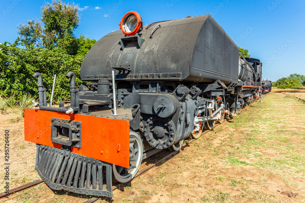 Obraz premium Old retro steel locomotive train standing on the rails in Livingstone, Zambia