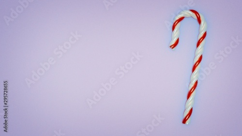 3D illustration. Red and white candy stick on a pale blue background with left copy space