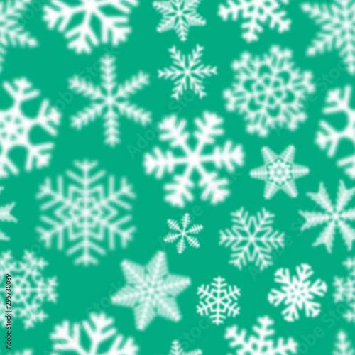 Christmas seamless pattern of white defocused snowflakes on turquoise background