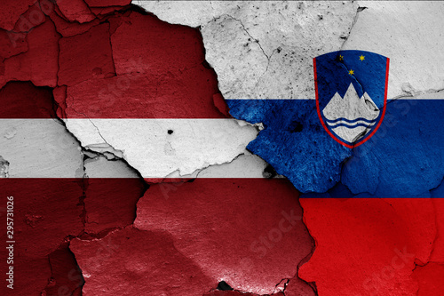 flags of Latvia and Slovenia painted on cracked wall