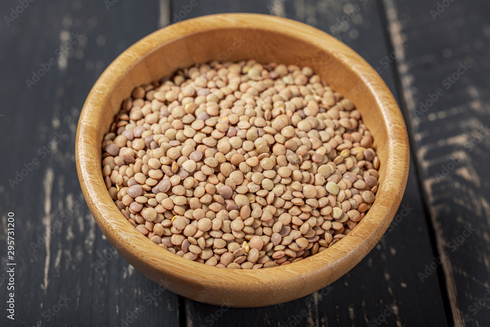Uncooked green lentils on wooden black table Uncooked green lentils on wooden black table
