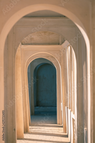 Archway with a play of light and shadow in eastern style. Gallery of arches in perspective in sunlight