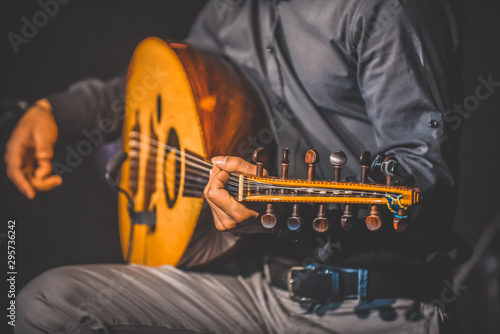 Φωτογραφία Toned image of musician playing traditional Turkish oud during concert with ligh