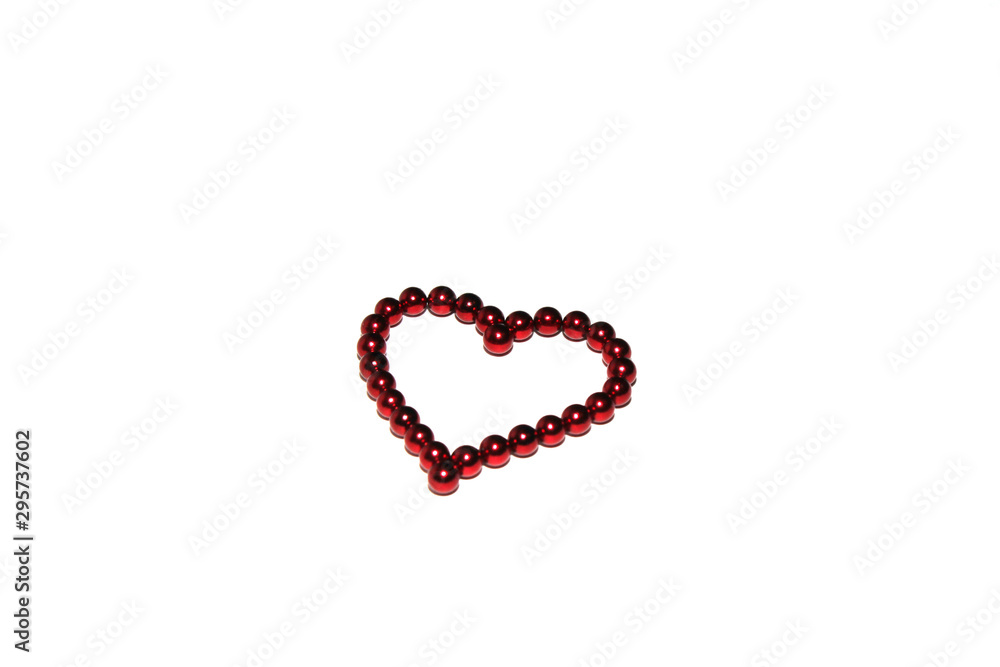 Red heart made of red magnetic beads is isolated on white background.