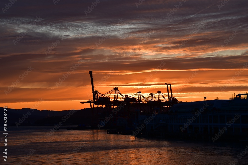 A picture of the silhouette of Metro Vaancouver's port against the sunrise. Vancouver BC Canada