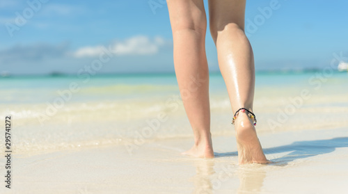 Beach travel concept. Sexy Legs on Tropical Sand Beach. Walking Female Feet. Closeup
