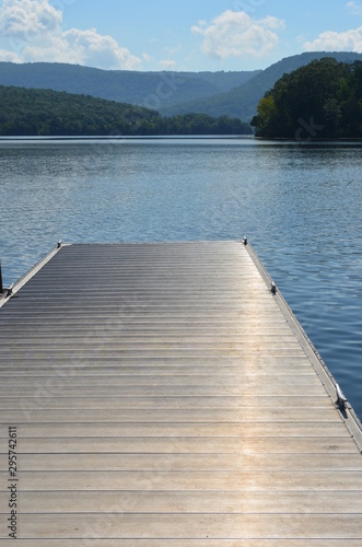 A dock over a lake with mountains in the background.