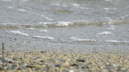 Wallpaper Mural ow point of view over an out-of-focus pebbled beach with a splashing wave Torontodigital.ca