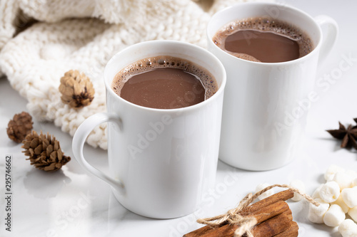 White ceramic cups of hot cocoa on top of white marble background