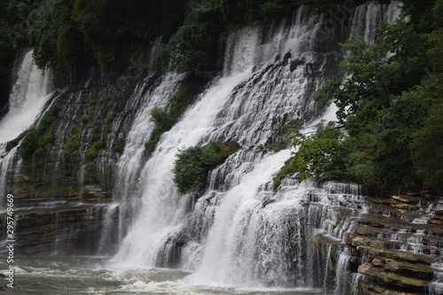 Multiple waterfalls over rock.