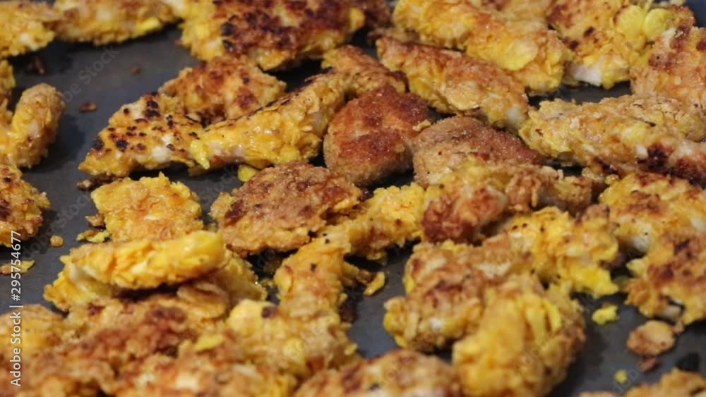 Fried chicken preparation on baking sheet for oven. Crispy meat appetizer grilled with egg and flour. Healthy and organic fast food meal. Cooking time in a restaurant kitchen, team work with a chef. Fried chicken preparation on baking sheet for oven. Crispy meat appetizer grilled with egg and flour. Healthy and organic fast food meal. Cooking time in a restaurant kitchen, team work with a chef.