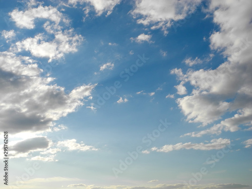 Fotografija White clouds against a blue sky backlit by the sun's rays