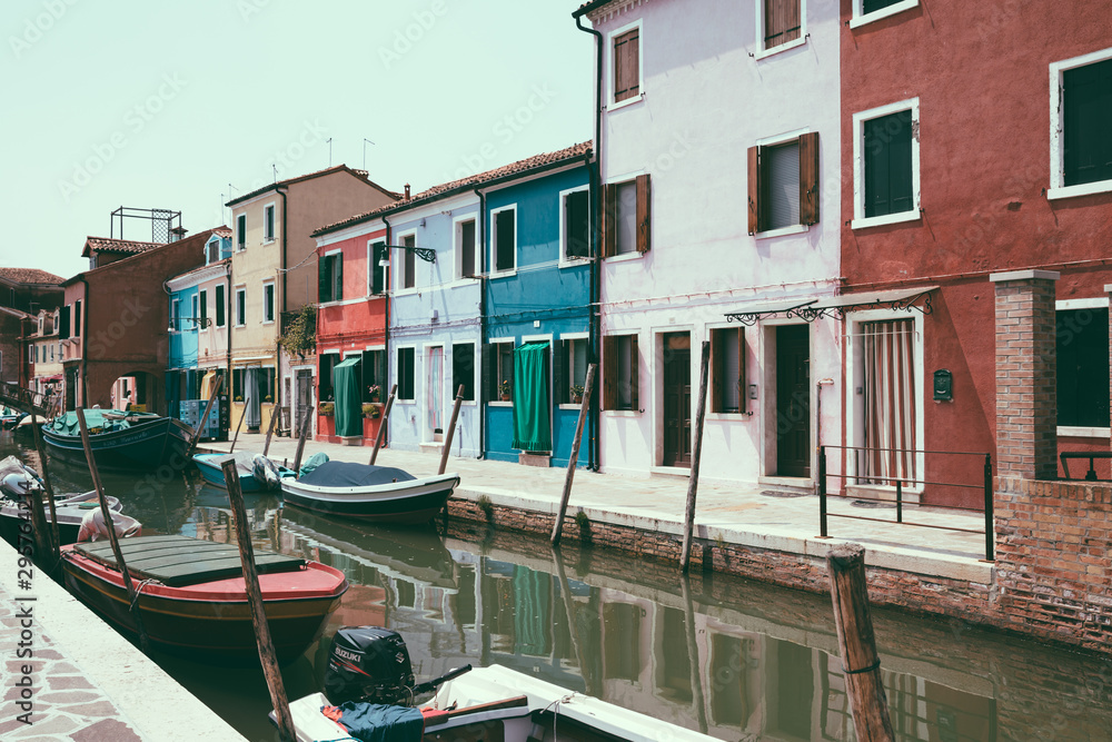 Panoramic view of coloured homes and water canal with boats in Burano