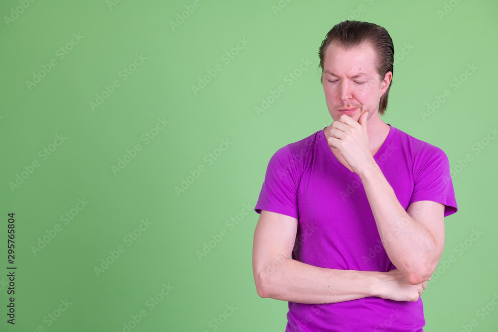 Portrait of young handsome man thinking and looking down Portrait of young handsome man thinking and looking down