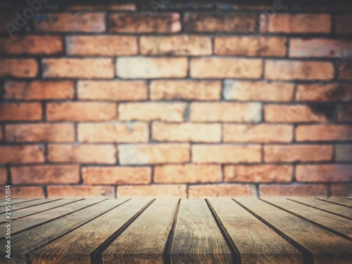 On top of an empty wooden table, the backdrop is a wall of blocks