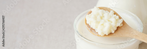 Foto Organic probiotic milk kefir grains, Tibetan mushrooms on wooden spoon and kefir