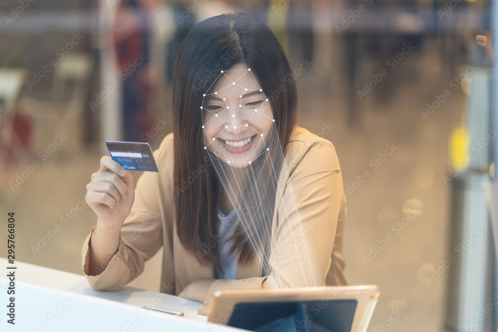 Asian women using the technology tablet for access control by face recognition in private identification step when online shopping with the credit card, credit card mockup, online payment concept,