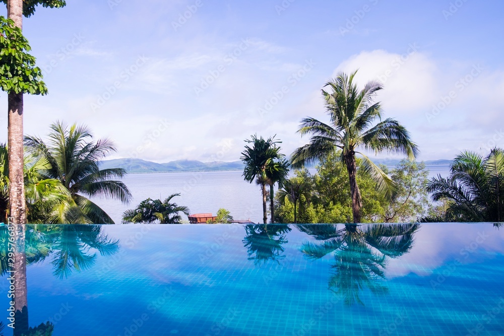 Coconut trees on the beach reflex with swimming pool beside the sea Coconut trees on the beach reflex with swimming pool beside the sea