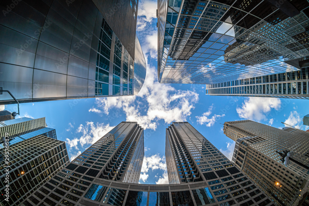 Fototapeta premium Uprisen angle with fisheye scene of Downtown Chicago skyscraper with reflection of clouds among high buildings which have airplane flying over the sky, Illinois, United States, Business concept