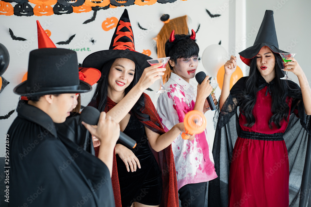 Obraz premium Gang of teen Asian celebrate Halloween for sing a song and drink, dessert in the room.