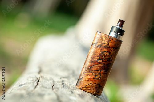 high end natural stabilized wood box mods with rebuildable dripping atomizer, vaping device, selective focus photo