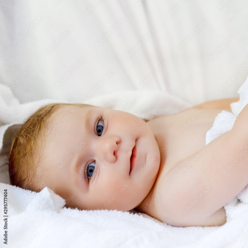 Cute little baby playing with own feet after taking bath. Adorable beautiful girl wrapped in white towels. Happy healthy baby Cute little baby playing with own feet after taking bath. Adorable beautiful girl wrapped in white towels. Happy healthy baby