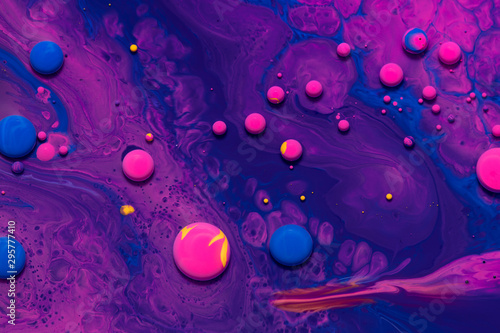Acrylic paint balls abstract texture. Purple, blue and pink liquids mix. Creative multicolor background. Bright colors fluid, flowing wallpaper design. Mixed pigments violet backdrop.