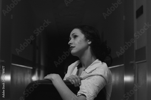 black and white photo of a girl in an evening dress with beautiful hands on a dark background © albert
