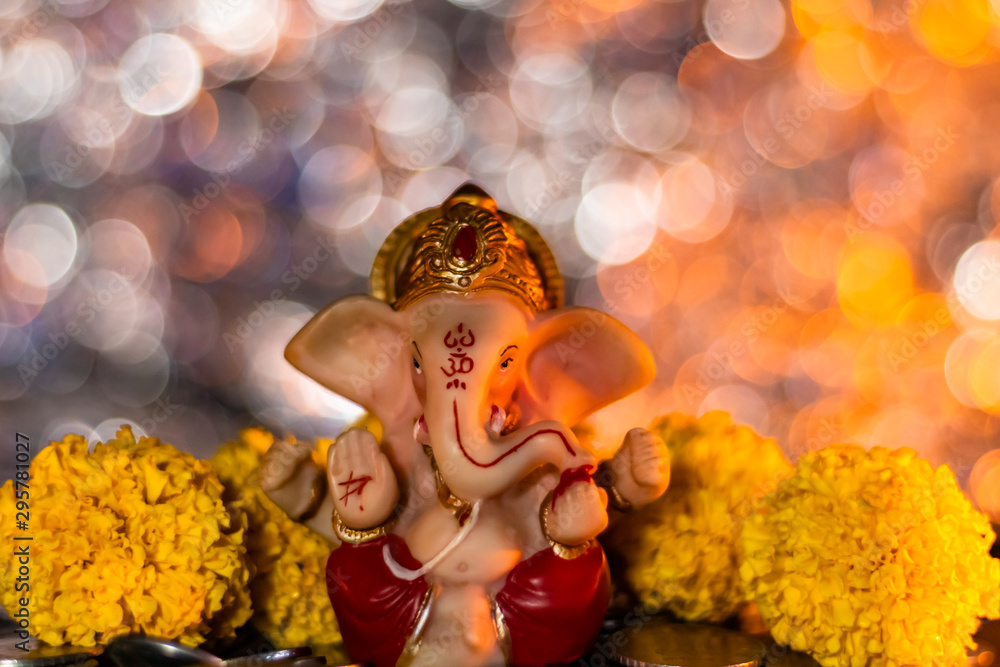 Small ganesh statue with yellow marigold flowers around and beautiful