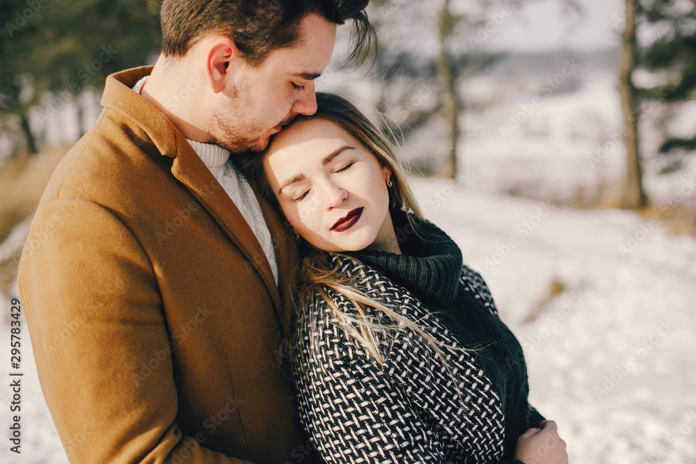 Fototapeta premium happy young couple walking through the park on a snowy day