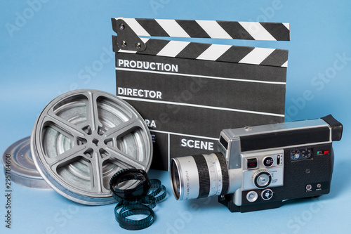 Clapperboard; film reel and camcorder on blue background
