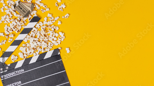 Clapperboard; popcorns and cinema tickets on yellow background