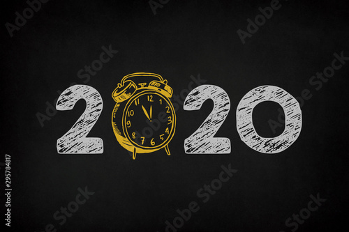New Year 2020 Concept with clock on Chalkboard