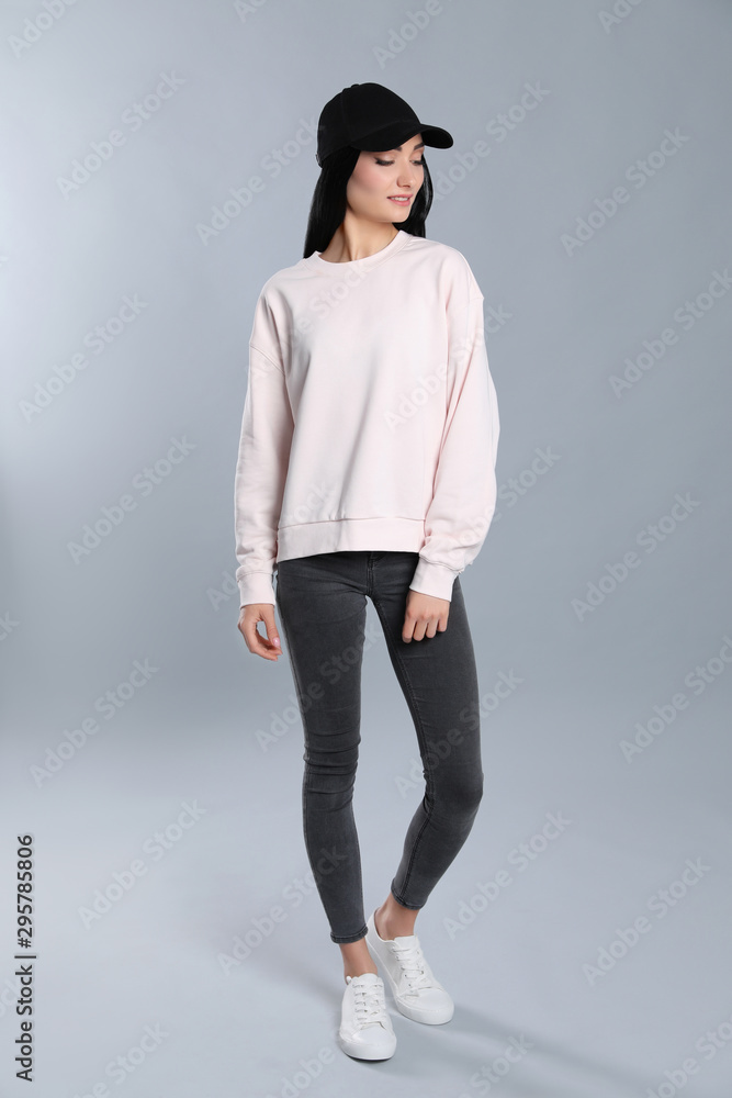 Full length portrait of young woman in sweater on grey background. Mock up for design Full length portrait of young woman in sweater on grey background. Mock up for design
