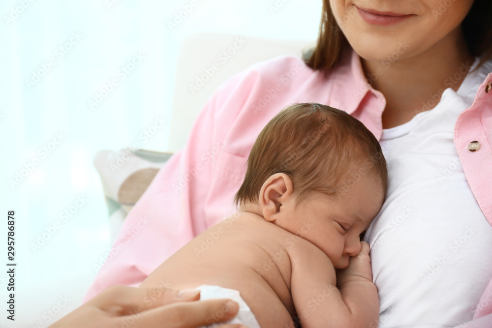 Young mother with her little baby on light background Young mother with her little baby on light background