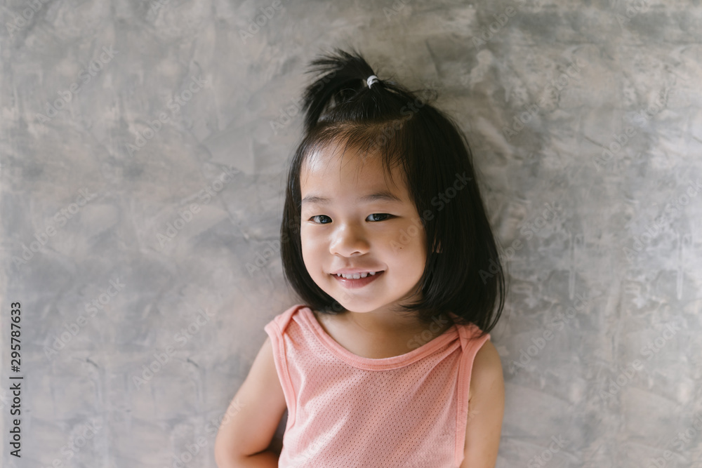Close-Up Portrait Of Cute Girl Standing Against Wall Close-Up Portrait Of Cute Girl Standing Against Wall