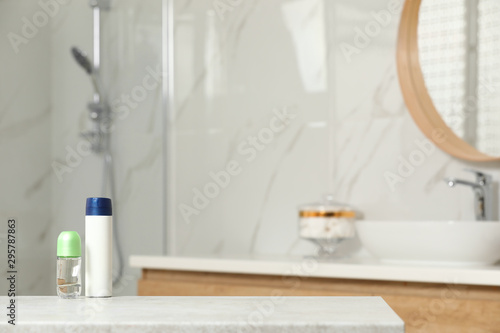 Different deodorants on table in bathroom  space for text