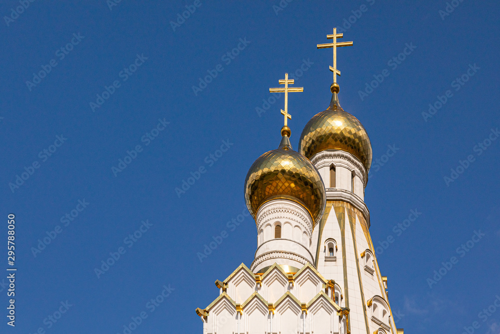 Two christian church gilt domes with crosses against blue sky