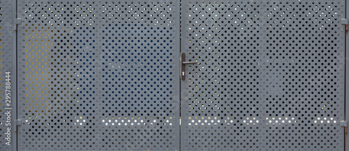 Panorama of metal gates with round openings photo