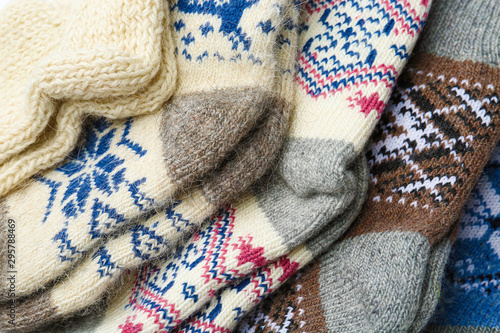 Different knitted woolen socks as background, closeup