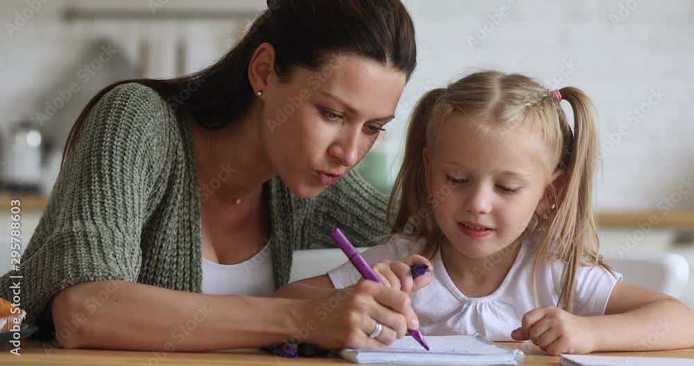 Happy mom teaching kid girl drawing with felt pen together Happy mom teaching kid girl drawing with felt pen together