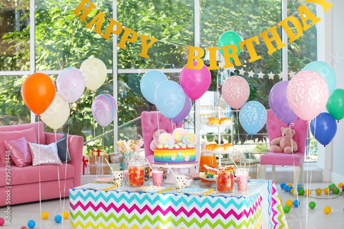 Photography Bright birthday cake and other treats on table in decorated room