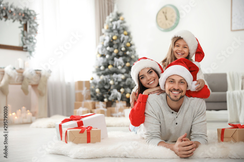 Portrait of happy family with Christmas gifts on floor at home