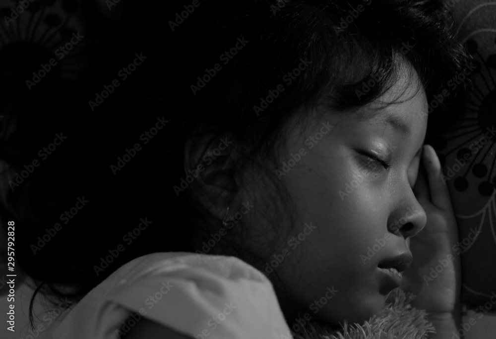 Black and white portrait of little Asian girl sleeping at home
