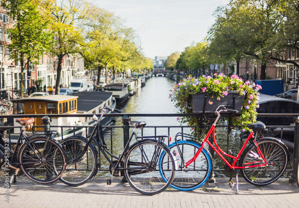 Charming canal with boat houses and bicycles in Amsterdam old town, Netherlands. Popular travel destination and tourist attraction. City life concept