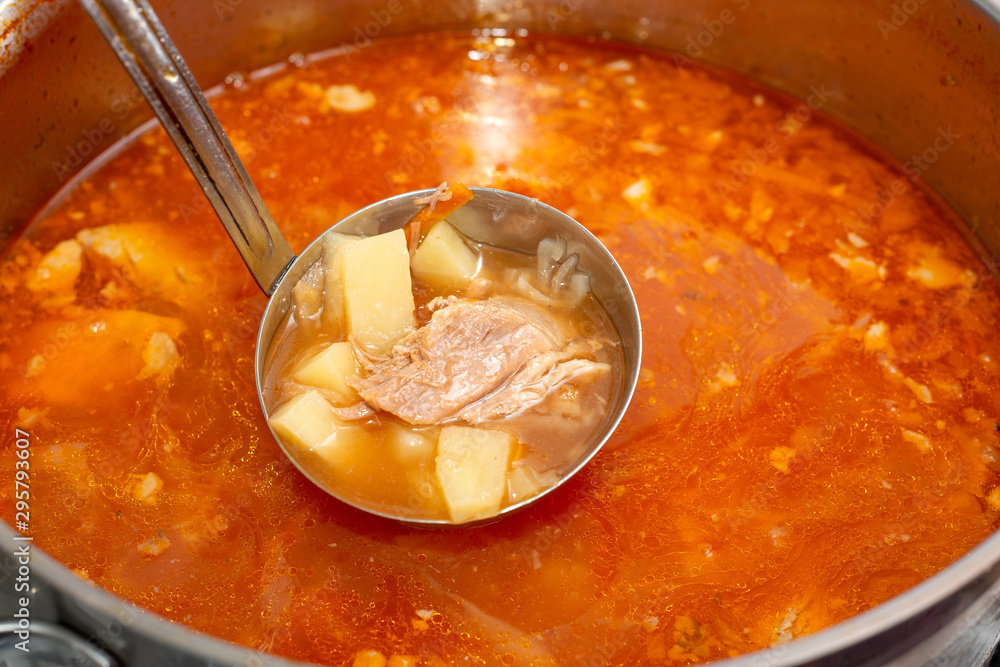 Red borsch in a saucepan with cabbage and fat, meat in a soup ladle. Red borsch in a saucepan with cabbage and fat, meat in a soup ladle.